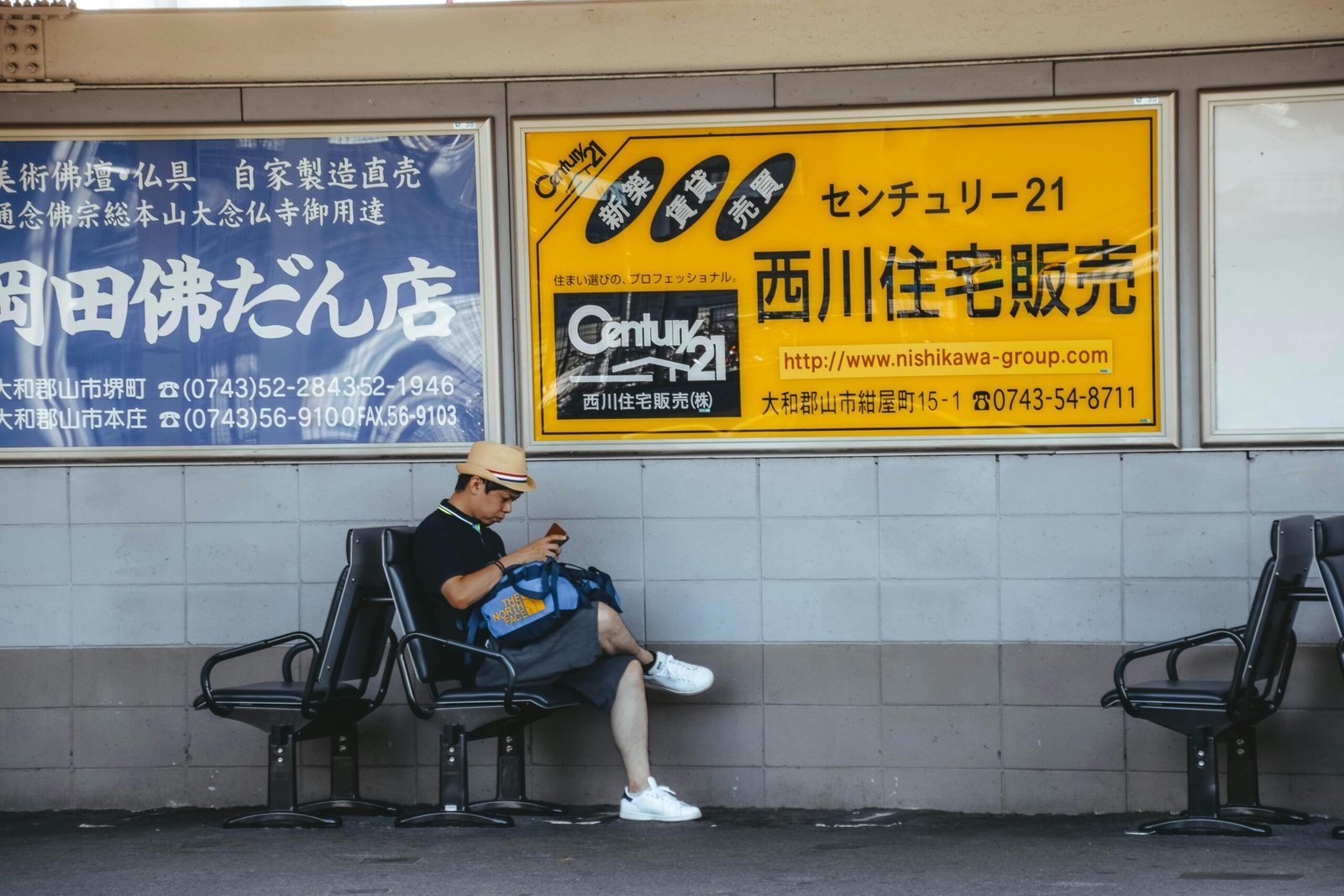 A man sitting on a bench reading a newspaper